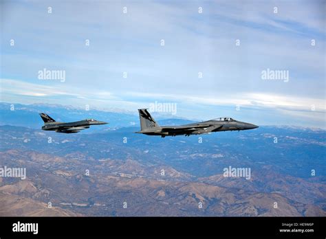 A U S Air Force F 15 Eagle And An F 16C Fighting Falcon Fly Over The