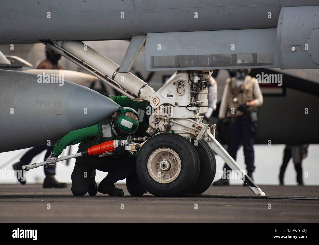 Aviation Boatswain S Mate Places A Hold Back Bar On An F A 18E Super